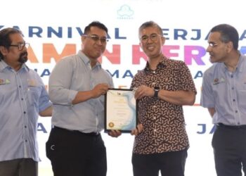 TENGKU Zafrul menyerahkan faedah Perkeso kepada seorang penerima pada Karnival Kerjaya Jamin Kerja Keluarga Malaysia di Kuala Selangor, hari ini. - FOTO/ISKANDAR SHAH MOHAMED