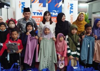 TEO Nie Ching (berdiri tengah) bersama murid-murid keluarga B40 dalam Program Sumbangan Baju Raya Sempena Program Cahaya Ramadan Bersama Telekom Malaysia di Kulai, Johor, hari ini.