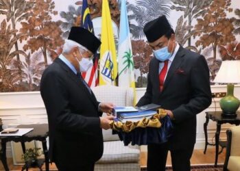 AHMAD Fuzi Abd. Razak (kiri) menyampaikan cenderamata kepada Mustapha Ahmad Marican di pejabatnya di Pulau Pinang, hari ini.