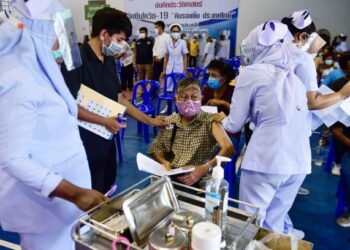 PENDUDUK menerima suntikan vaksin Covid-19 di luar perkarangan Hospital Narathiwat di Thailand. - AFP
