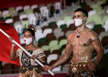 PEMBAWA bendera Tonga, Pita (kanan) berarak masuk ke lapangan bersama Malia Paseka di Stadium Olimpik, Tokyo.