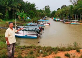 NELAYAN menunjukkan keadaan bot memancing udang yang tersadai di Kampung Sungai Dulang dekat Bagan Datuk, Perak, semalam. - UTUSAN/AINSAFRE BIDIN
