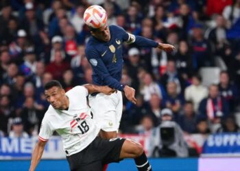 PERTAHANAN Perancis, Raphael Varane (kanan) bersaing dengan penyerang Austria, Karim Onisiwo dalam aksi Liga Negara-Negara UEFA di Stade de France, Paris. - AFP