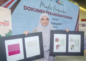 Ts Dr. Ros Mahwati menunjukkan corak hiasan Melayu tradisional yang dikomersialkan melalui produk pakaian pada Majlis Penyerahan Dokumen Perjanjian Perlesenan antara Inovasi@UKM dengan Siti Khadijah Apparel Sdn. Bhd. di UKM, Bangi. – UTUSAN/AMIR KHALID