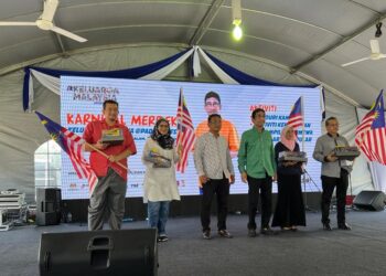 ZAHIDI Zainul Abidin (tiga dari kanan) membuat penyerahan bendera kepada barisan ADUN sewaktu Majlis Perasmian Karnival Merdeka Keluarga Malaysia@Padang Besar di Kampus Uniciti Alam Sungai Chuchuh Unimap di Padang Besar, Perlis, hari ini. - UTUSAN/ASYRAF MUHAMMAD