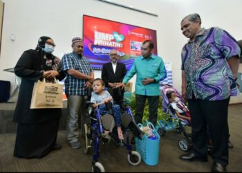 IBRAHIM Ahmad (dua dari kanan) menyatakan sesuatu kepada keluarga anak-anak istimewa yang dirai dalam Program Prihatin UMP sempena menyemarakkan bulan kemerdekaan di UMP Kampus Pekan, di Pekan, Pahang.