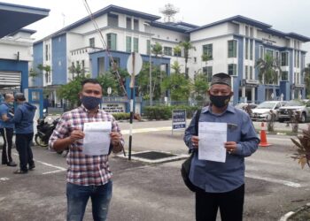 ZAMRIN Hamzah (kanan) dan Mohd. Fairuz Iskandar Abdul Aziz menunjukkan salian laporan polis dibuat terhadap Lim Kit Siang agar tindakan segera diambil terhadapnya di IPD Seri Alam, Johor Bahru, Johor. - UTUSAN/KHAIRUL MOHD ALI