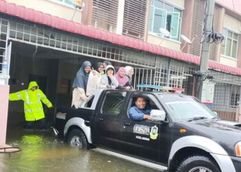 ANGGOTA Jawatankuasa Task Force Banjir membantu memindahkan pelajar UniSZA, Kuala Nerus, Terengganu ke asrama  di kampus Gong Badak, Kuala Nerus, Terengganu, hari ini. - UTUSAN/KAMALIZA KAMARUDDIN
