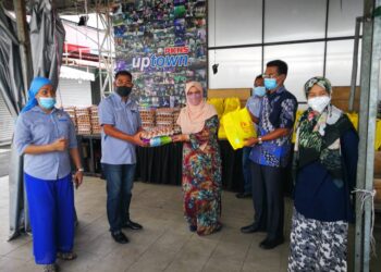 RODZIAH Ismail (tengah) menyerahkan sumbangan kepada  Hassan Nuruddin di Uptown Shah Alam, Seksyen 24, Shah Alam, Selangor. - UTUSAN / ABDUL RAZAK IDRIS