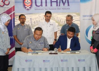 MOHD. NORLISAM MOHD. NORDIN (duduk, kanan) dan Ruzairi Abdul Rahim memeterai MoU antara UTHM dan SWM di Kampus UTHM Pagoh, Muar.
