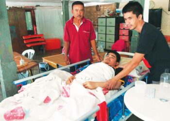 MANOP Cham Ren (kanan) menguruskan adik keduanya, Sornram yang terlantar akibat penyakit saraf ketika ditemui di rumah saudara mereka di Kampung Pegang, Kuala Pegang di Baling. – UTUSAN/NORLIA RAMLI