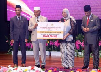 IDRIS Ahmad menyerahkan replika cek agihan dana wakaf tunai Yayasan Waqaf Malaysia kepada penerima pada Perhimpunan Agensi dan Majlis Apresiasi Menteri di Jabatan Perdana Menteri (Hal Ehwal Agama) di Putrajaya. - UTUSAN/ FAISOL MUSTAFA