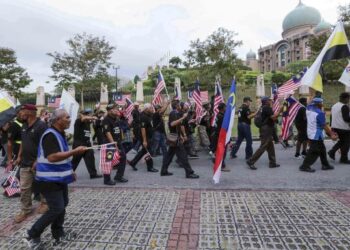 SEBAHAGIAN daripada ahli PSPRM berjalan menuju ke pejabat Perdana Menteri bagi menyerahkan memorandum tuntutan veteran ATM di Putrajaya. - FOTO/FAISOL MUSTAFA