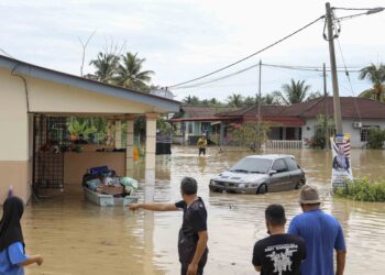 PENDUDUK kampung melihat keadaan rumah yang terjejas akibat banjir di Kampung Cemperai Dengkil, Selangor. - UTUSAN/FAISOL MUSTAFA
