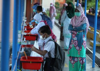 MURID-MURID perlu sentiasa diingatkan mencuci tangan menggunakan cecair pembersih sebelum menaiki bas sekolah. - UTUSAN/ZULHANIFA SIDEK

ZULHANIFA SIDEK