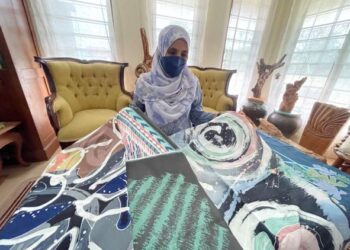 ZARINA Salleh menunjukkan batik yang dilukis menggunakan berus dengan motif abstrak di bengkelnya di Kampung Ngulang, Datuk Kayaman, Kangar, Perlis, hari ini. - UTUSAN/NAZLINA NADZARI