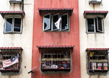 Kelihatan Yeo Kiat Ming (belakang tingkap) mengibarkan "bendera putih" sebagai simbolik keluarga mereka memerlukan bantuan keperluan asas berikutan Perintah Kawalan Pergerakan Diperketatkan (PKPD) di Flat Bukit Tinggi, Bandar Bukit Tinggi, Klang, Selangor, semalam. -  UTUSAN/ZULFADHLI ZAKI