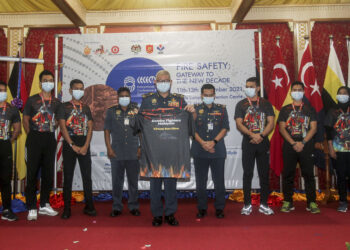 MOHAMMAD Hamdan Wahid (lima kiri) menunjukkan baju rasmi Bomba Fighters Malaysia Virtual Run 2021 di Ibu Pejabat JBPM, Putrajaya. - UTUSAN/FAISOL MUSTAFA
