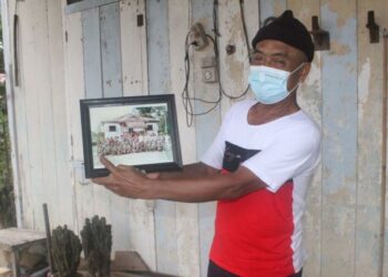 MUSA A. Rahim menunjukkan gambarnya bersama pelakon filem Bukit Kepong di hadapan balai polis yang dibina semula pada tahun 1980 ketika ditemui di rumahnya di Kampung Serkat, Pontian, Johor. –  FOTO/MUHAMMAD ZIKRI