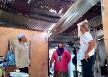 MUHAMAD Ridzuan Suhaimi (kiri) melihat bumbung rumah Sanira Abu Seman (tengah) yang rosak semasa melakukan lawatan kebajikan di Kampung Baru Air Nasi di Semeling, Sungai Petani, Kedah. – FOTO/OTHMAN YAHAYA