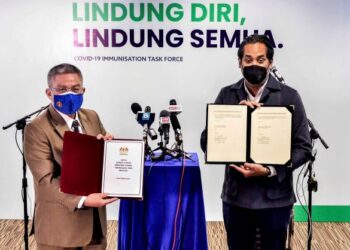 KHAIRY Jamaluddin (kanan) dan Adham Baba menunjukkan nota serah tugas jawatan Menteri Kesihatan dan Menteri Sains, Teknologi dan Inovasi di ibu pejabat CITF, Putrajaya.- UTUSAN/FAISOL MUSTAFA
