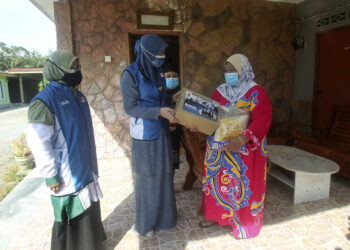 RINA Harun (tengah) menyerahkan sumbangan Bakul Prihatin kepada penduduk kampung, Noraini Dollah (kanan) semasa melawat ke Kampung Bukit Bangkong, Sungai Pelek, Sepang, Selangor. - FAISOL MUSTAFA