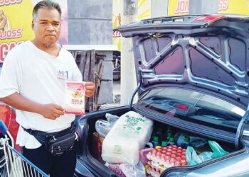 AZAMI Awang menunjukkan sepaket gula pasir sahaja yang dibenarkan dibeli semasa berurus niaga di sebuah pasar borong di Sungai Petani. -UTUSAN/OTHMAN YAHAYA