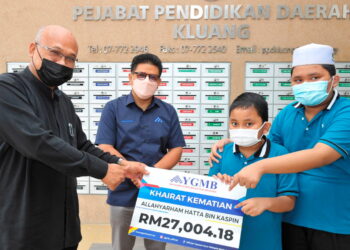 MD. Said Md. Daimon (kiri) menyerahkan khairat kematian kepada dua anak Hatta Kaspin sambil disaksikan Wan Munadi Wan Mamat (dua kiri) di PPD Kluang, Johor.