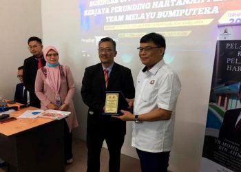 Mohd. Izhar Ahmad (kanan) menerima cenderamata selepas merasmikan  Seminar Grow Perunding Hartanah Bumiputera Daerah Kluang dan Pelancaran Kelab Pelaburan Harta Tanah Bumiputera Johor, semalam.