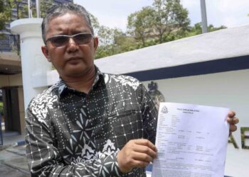 KAMARUL Zaman Yusoff menunjukkan laporan polis yang dibuat ke atas Lokman Noor Adam di IPD Putrajaya. - FOTO/FAISOL MUSTAFA