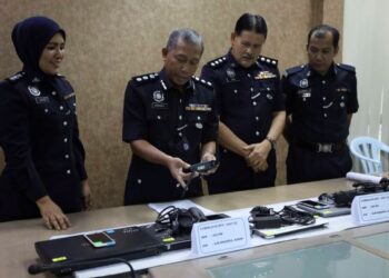 WAN Kamarul Azran Wan Yusof (dua dari kiri) melihat barang rampasan kes sindiket penipuan tawaran kerja di IPD Sepang, Selangor. - FOTO/FAISOL MUSTAFA