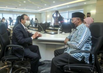 IDRIS Ahmad (kanan) berbual bersama Ouyang Yujing (kiri) pada majlis penyampaian sumbangan Kedutaan China di Malaysia kepada JAWI Food Bank di Kompleks Islam Putrajaya. - UTUSAN/FAISOL MUSTAFA