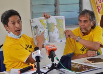 GOOI Hsiao Leung (kiri) menunjukkan peta dan lokasi Bukit Juru yang didakwa ditarah sejak 40 tahun lalu sehingga menjejaskan kehidupan penduduk di Kampung Sungai Semilang, Juru, Pulau Pinang, semalam.
