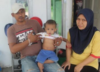 LOKMAN Nol Hakim Abd. Hamid meriba Ammar Zaffran yang menghidap penyakit kanser buah pinggang ketika ditemui bersama isterinya, Zuhaila Ahmad di rumah mereka di Kampung Sungai Buntu, Penerok, Pontian, Johor. - UTUSAN/MUHAMMAD ZIKRI