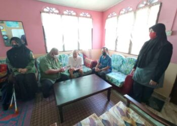 AIMAN Michael (tiga dari kiri) bersama Siti Dakwah Abdul Aziz (berdiri, kanan) menerima kunjungan Nasaruddin Ahmad yang menyerahkan bantuan wang tunai di kediamannya di Felda Air Tawar 2, Kota Tinggi di Johor.