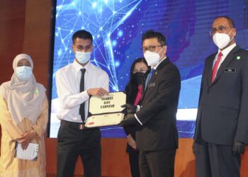Ti Lian Ker (dua kanan) menyampaikan sijil tamat latihan program inklusiviti belia autisme ILKBS 2020 kepada Ahmad A'qil Firdaus Mohd Fauzi (dua kiri) pada Majlis Penyampaian Anugerah Institusi Latihan Kemahiran Belia dan Sukan (ILKBS) 2020/2021 di Parcel F, Presint 1 di sini, hari ini.-UTUSAN/ FAISOL MUSTAFA