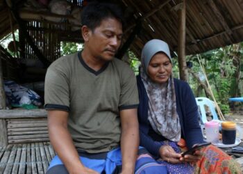 Ibu bapa, Md Sharif Md Daud,45 dan Rozita Md Isa, 45, menunjukkan perbualan terakhir di dalam whatsapp bersama anak mereka, Siti Nor Sufieza, 23 yang menjadi mangsa bunuh di Jitra, kelmarin.-UTUSAN/ SHAHIR NOORDIN