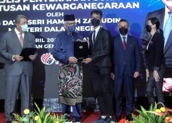 HAMZAH Zainudin menyerahkan surat kewarganegaraan kepada Gan Chun Kai, 14 (tiga kanan) dan ibunya, Looi Mei Fong, 53 (kanan) pada majlis penyerahan surat keputusan kewarganegaraan di Putrajaya. - UTUSAN/FAISOL MUSTAFA