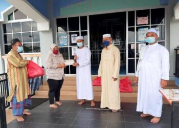 MUHAMMAD Mufarizam Yahir (tengah) menyampaikan sumbangan kepada salah seorang anak yatim daripada wang hasil jualan barangan kitar semula Masjid Bandar Putra di Segamat, Johor. - UTUSAN/FARAHWAHIDA AHMAD