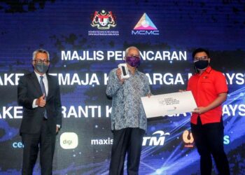 ANNUAR Musa menyampaikan Pakej Remaja Keluarga Malaysia dan Pakej Peranti Keluarga Malaysia kepada pelajar, Muhammad Alif Azri (kanan) di Kementerian Komunikasi dan Multimedia Malaysia (KKMM), Putrajaya. - UTUSAN/FAISOL MUSTAFA