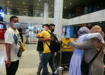 Abdul Jalal Mohd Tahir, 58,  gembira menyambut isterinya, Khadijah Ahmad , 54, dan anaknya, Mikayl Abdul Jalal, 22,  yang terpisah hampir dua tahun  tiba menggunakan Laluan Perjalanan Vaksinasi (VTL) pada penerbangan pertama pesawat Singapore Airlines SQ108 yang mendarat di Lapangan Terbang Antarabangsa Kuala Lumpur (KLIA), Sepang semalam. - UTUSAN/FAISOL MUSTAFA
