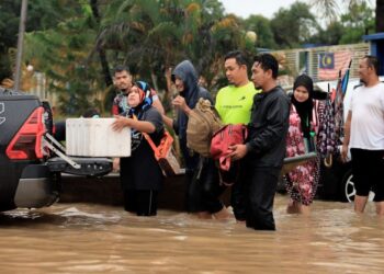 BEBERAPA mangsa banjir mengangkat barang-barang ke dalam kenderaan pacuan empat roda untuk dipindahkan ke kawasan yang lebih selamat di Lubuk Jong, Pasir Mas, Kelantan.-UTUSAN/KAMARUL BISMI KAMARUZAMAN