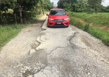 KEADAAN jalan yang berlubang dan rosak memberikan kesukaran untuk penduduk melakukan urusan harian mereka di Kampung But, Ketereh, Kota Bharu, Kelantan. - UTUSAN/ROSMIZAN RESDI