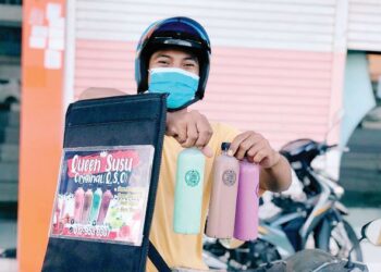NIK Muhamad Afiq menunjukkan susu berperisa keluaran sendiri, Queen Susu Original yang dijual sekitar Kota Bharu. - UTUSAN/ ROSLIZA MOHAMED