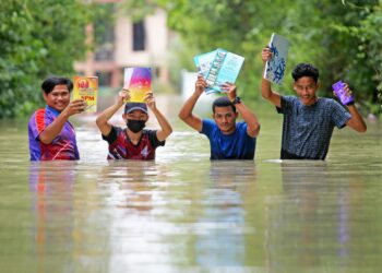 Empat pelajar Sijil Pelajaran Malaysia dari Sekolah Menengah Agama Pohon Buloh meredah air banjir ketika balik dari kelas tambahan di Kampung Senor Pasir Mas di sini semalam. -UTUSAN/ZULHANIFA SIDEK