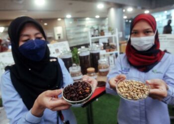 KAKITANGAN Jabatan Pertanian menunjukkan biji kopi spesies Liberica dan Robusta pada Sambutan Hari Kopi Sedunia di Wisma Tani, Putrajaya. - UTUSAN/FAISOL MUSTAFA