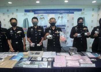 MOHD. Fauzi Hassan (tiga kanan) menunjukkan sebahagian barang rampasan hasil serbuan empat premis pajak gadai tidak berlesen di Putrajaya. - UTUSAN/FAISOL MUSTAFA