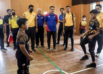 RADZI Jidin melihat pelajar bermain sepak takraw semasa Program Pengukuhan Sukan Sepak Takraw di SK Presint 5 (1) Putrajaya. - UTUSAN/FAISOL MUSTAFA