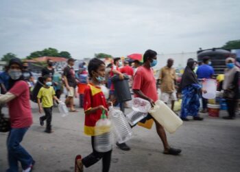 PENDUDUK membawa botol dan bekas kosong untuk mendapatkan bekalan air daripada lori tangki Air Selangor di Petaling Jaya, Selangor, baru-baru ini. – UTUSAN/MUHAMAD IQBAL ROSLI