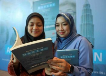 KAKITANGAN awam, Wan Farah Wan Nasrudin (kanan) dan Nor Zarifah Saleh melihat buku MADANI pada Majlis Amanat PM Membangun Malaysia (MADANI) di Pusat Konvensyen Antarabangsa Putrajaya (PICC), Putrajaya. - UTUSAN/FAISOL MUSTAFA
